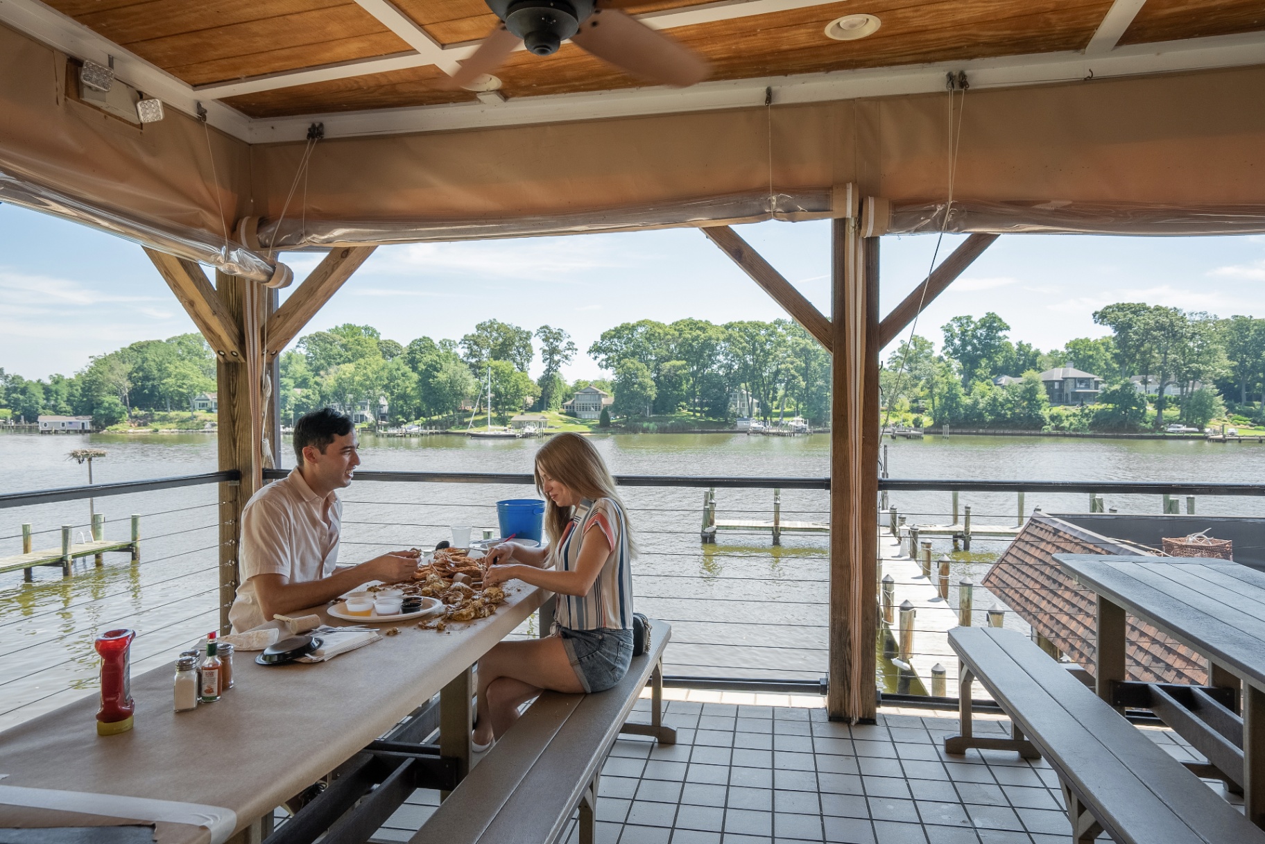 Couple eating steamed blue crabs at Cantler's Riverside Inn on the water