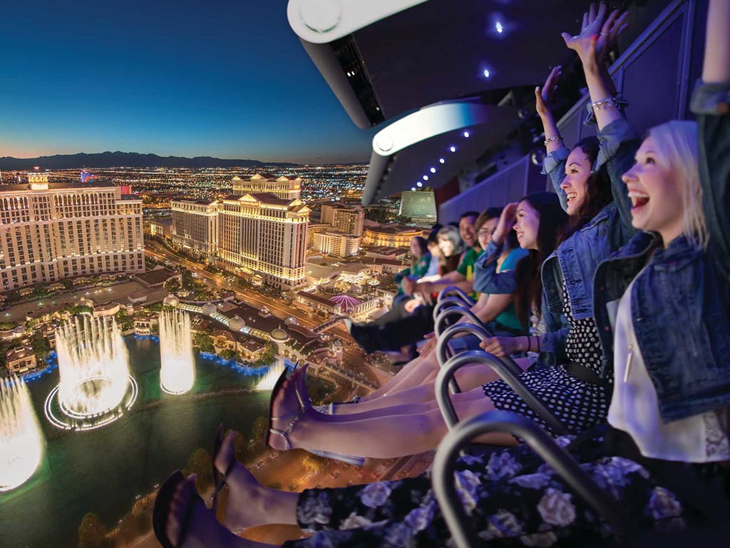 Guests on the High Roller observation wheel above the Bellagio fountains